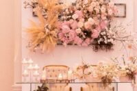 a glam and refined wedding sweetheart table with blooms at the base and a jaw-dropping floral installation behind, no foam used