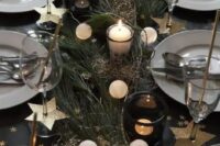 a homey NYE wedding tablescape with evergreens, a lights garland, candles, gold stars