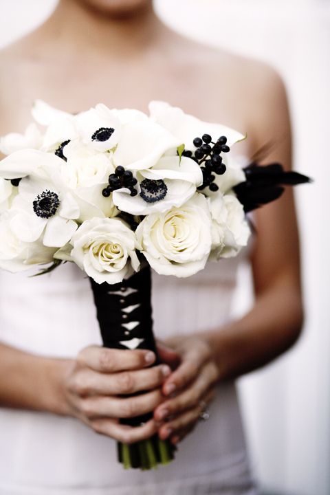 a laconic black and white wedding bouquet of white roses and anemones, black berries and with a black wrap is a cool idea