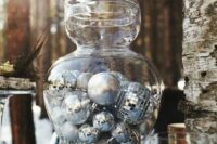 a large glass jar filled with various silver ornaments is a great idea for a centerpiece for NYE or Christmas