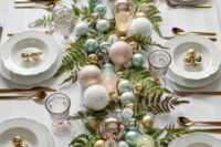 a lovely NYE wedding centerpiece of fern, candy-colored ornaments and some candles is a great idea with a soft touch of color