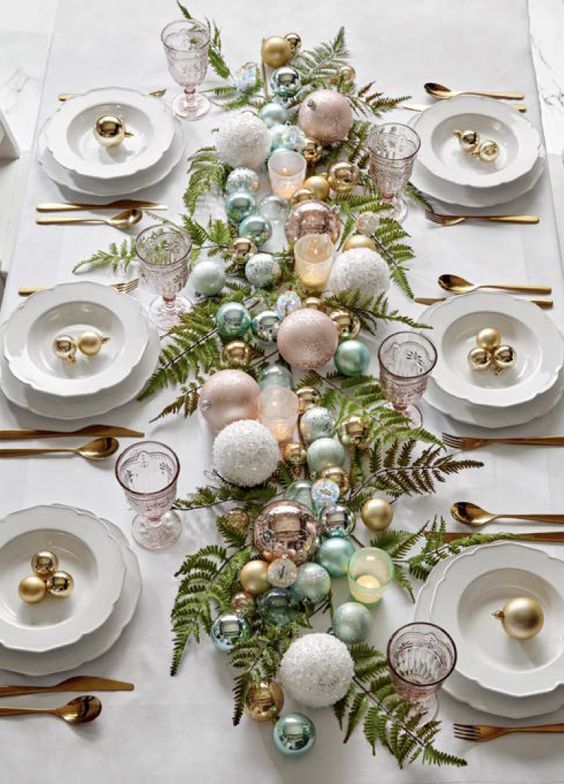 a lovely NYE wedding centerpiece of fern, candy colored ornaments and some candles is a great idea with a soft touch of color