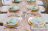 a lovely pastel wedding tablescape with a pink sequin tablecloth, gold-rimmed plates and mint grene napkins, gold-rimmed glasses