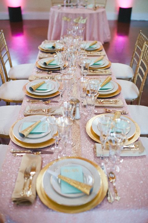a lovely pastel wedding tablescape with a pink sequin tablecloth, gold rimmed plates and mint grene napkins, gold rimmed glasses