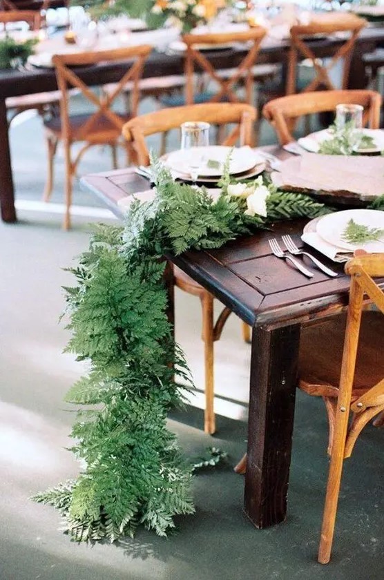 a lush fern table runner with some white blooms is a great idea for a woodland or rustic wedding