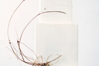 a minimalist beach square white wedding cake decorated with a bit of twigs is a beautiful piece that looks unusual