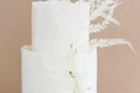 a minimalist white wedding cake decorated with dried white leaves is a beautiful idea for a summer or fall wedding