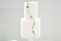 a pure white minimalist wedding cake decorated with a single fresh twig is amazing for a spring wedding