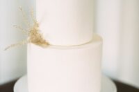 a pure white wedding cake decorated with just a couple of twigs of dried grass is a lovely idea for a minimalist wedding