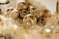a silver ornaments will be an easy, budget-friendly and glam centerpiece is a cool idea for a NYE wedding