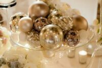a silver ornaments will be an easy, budget-friendly and glam centerpiece is a cool idea for a NYE wedding
