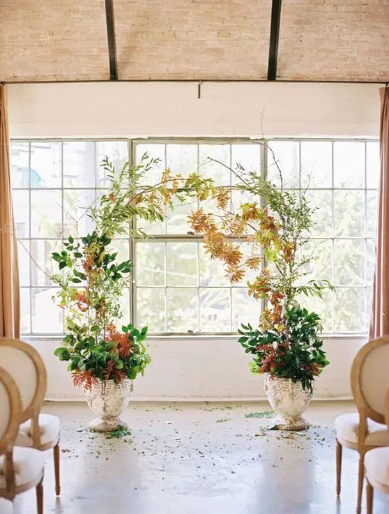 a simple and catchy fall wedding altar of greenery and bright fall leaf branches in pots is a stylish idea