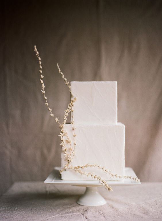 a square white wedding cake with a texture and a bit of dried blooms is a beautiful idea for a minimalist wedding