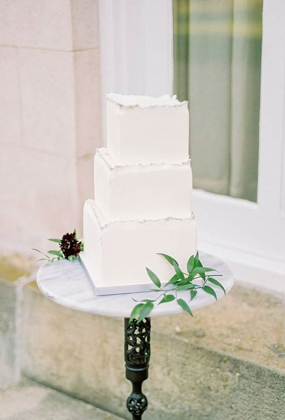 a stylish square wedding cake in pure white with a raw silver edge is a beautiful option for a minimalist wedding