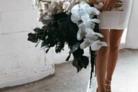 a unique wedding bouquet of white roses and orchids, black callas, dried grasses and twigs is a lovely idea for a modern bride