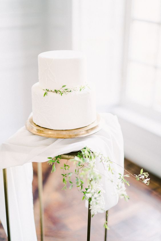 a white textural wedding cake topped with greenery is a beautiful idea for spring and summer weddings