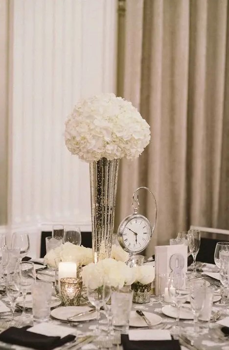 an elegant black and white tablescape with a clock to remind is a cool and stylish idea for a NYE wedding