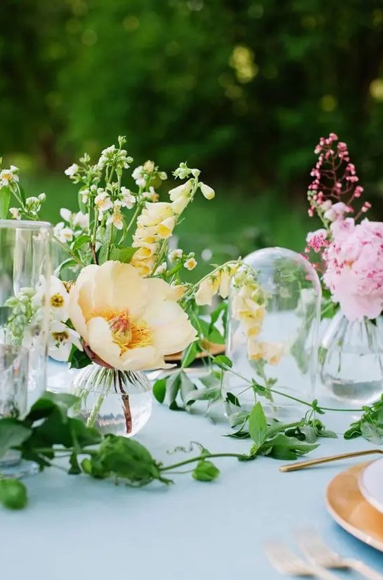 cluster wedding centerpieces of yellow poppies and pink peonies and a greenery runner are amazing for spring weddings