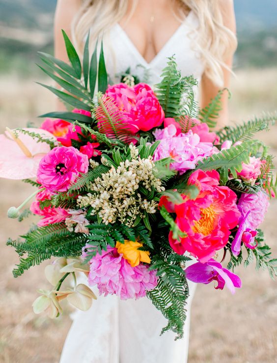 a bold and dimensional wedding bouquet of hot pink and yellow blooms, lots of greenery and leaves is an amazing idea