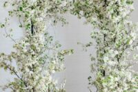05 a fab blooming wedding arch covered with white blooming branches and some greenery is a lovely idea for spring or summer