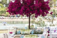 05 a neutral wedding reception space with white florals on the table and a bold fuchsia blooming tree is a fantastic solution that wows