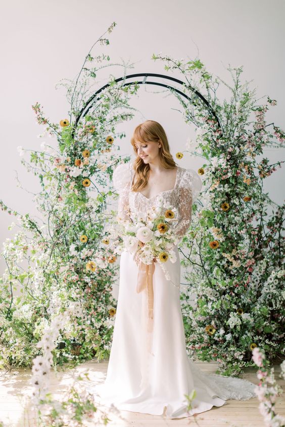 a fantastic wedding arch covered with greenery, white and yellow blooms and blooming branches is a perfect idea for spring