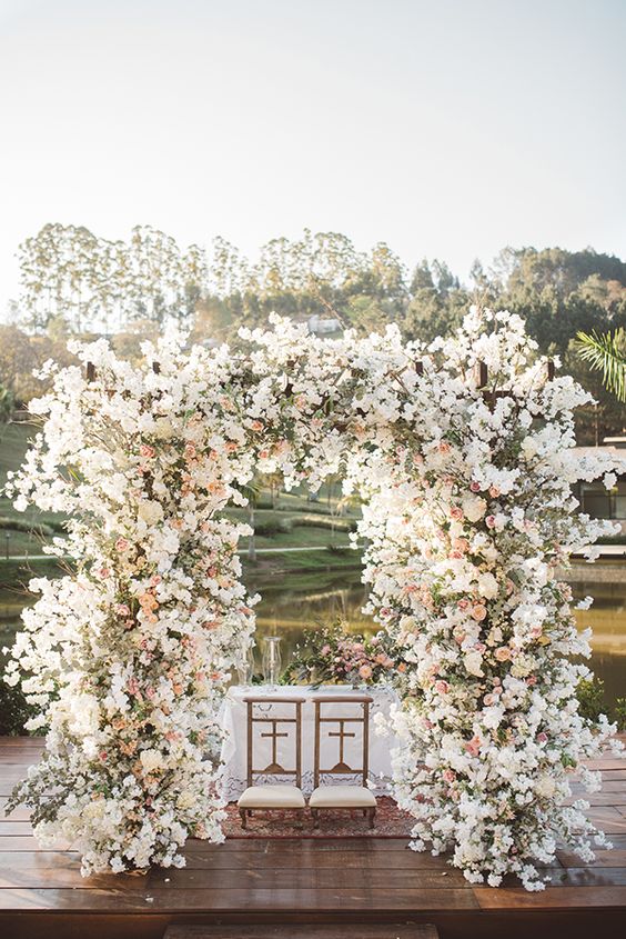 a fantastic wedding arch decorated with white and pink blooming branches all over will make a bold statement at your wedding