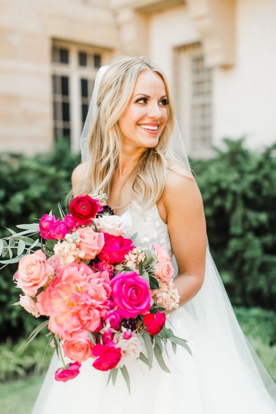 a bright pink wedding bouquet with peonies, roses and hot pink roses plus greenery is amazing