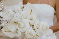09 a jaw-dropping white wedding bouquet that includes peony roses, orchids, roses, callas and dried white leaves