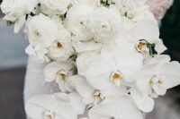 10 a cascading white wedding bouquet composed of ranunculus and orchids looks very sophisticated