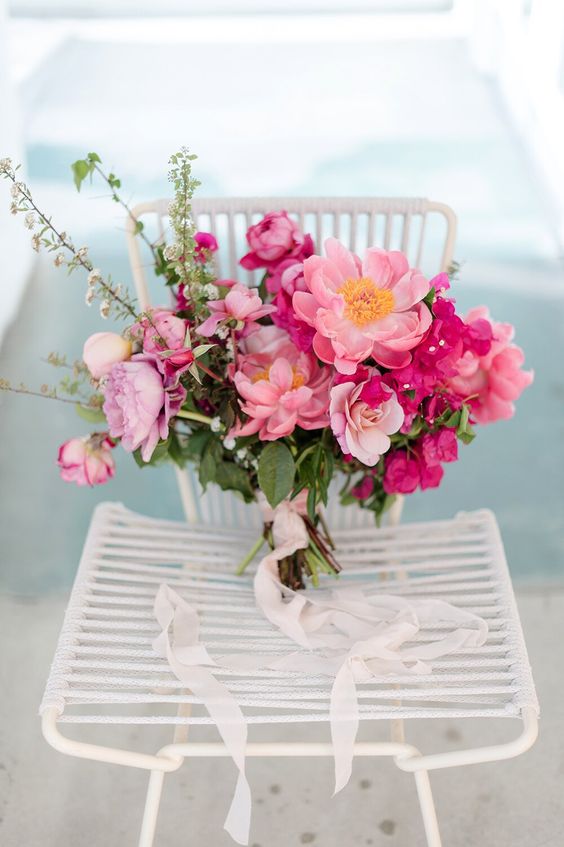 a beautiful pink wedding bouquet composed of pink peonies and fuchsia bougainvillea plus greenery