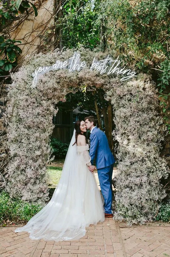 a jaw dropping wedding entrance or arch covered with white and blush baby's breath completely looks fantastic
