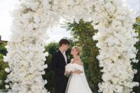 14 a jaw-dropping white wedding arch completely covered with white blooms is a fantastic idea for a refined wedding