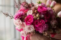 19 a pink wedding bouquet that includes blush, hot pink and fuchsia blooms and some waxflowers as fillers
