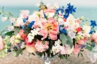 21 a bright secret garden wedding centerpiece of a glass bowl, bold pink and blue blooms and some foliage is chic and amazing