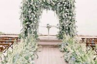 21 a super lush and beautiful wedding arch totally covered with greenery and white blooms and with a matching wedding aisle with such blooms