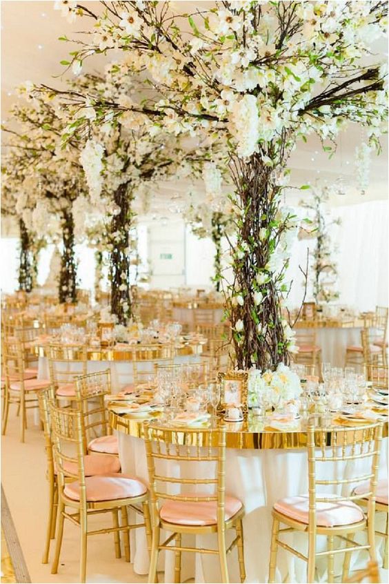 a fantastic wedding reception space with oversized centerpieces that imitate blooming trees looks jaw dropping