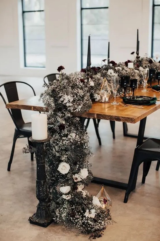 a jaw-dropping black and white wedding table runner of black and white blooms, fresh and dried ones, and black and white candles of various shapes