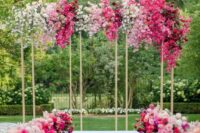 28 a modern wedding arch with white, light and hot pink blooms creating an ombre effect and matching flowers along the aisle