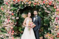 30 a colorful wedding arch decorated with greenery, blush, coral and pink blooms is a bold idea for a colorful summer wedding