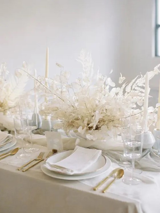 a really ethereal dried leaf wedding centerpiece with lunaria is ideal for an all white wedding tablescape and it looks chic and elegant