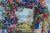32 a super lush and bold floral wedding arch with blooming branches and flowers of all shades possible and with greenery