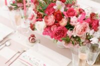 34 a bold and chic pink wedding centerpiece of light and hot pink blooms, greenery and white flowers plus pink candles