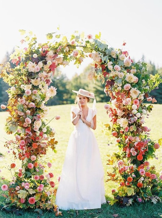 a jaw dropping wedding arch with some foliage, pink, blush, red and neutral blooms all over is amazing for a bright summer wedding