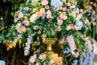 36 a beautiful and lush wedding centerpiece of pink, peachy, blue blooms, lots of greenery and a gilded vase is an amazing secret garden wedding centerpiece