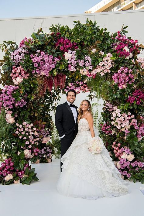 a lush and chic wedding arch decorated with greenery, blush, mauve and lilac blooms is an amazing idea for spring and summer