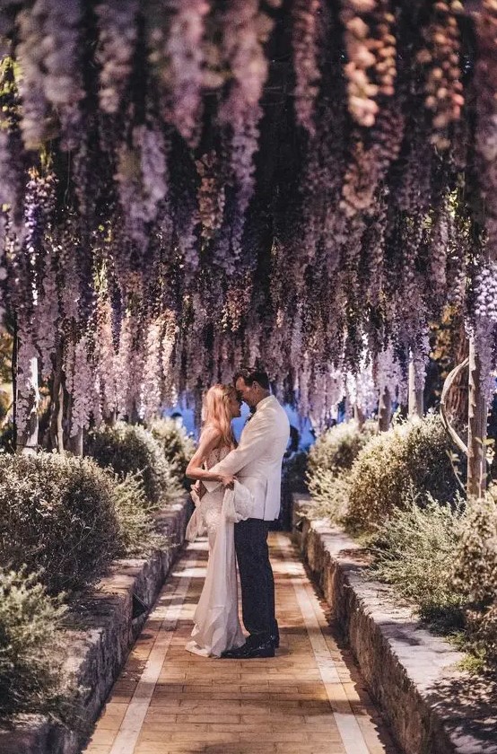 a gorgeous wedding corridor decorated with hanging purple delphinium looks very chic and bold and welcomes to take pics here