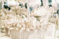 38 an exquisite tall wedding centerpiece of white blooms and greenery is a gorgeous idea for a refined all-white wedding