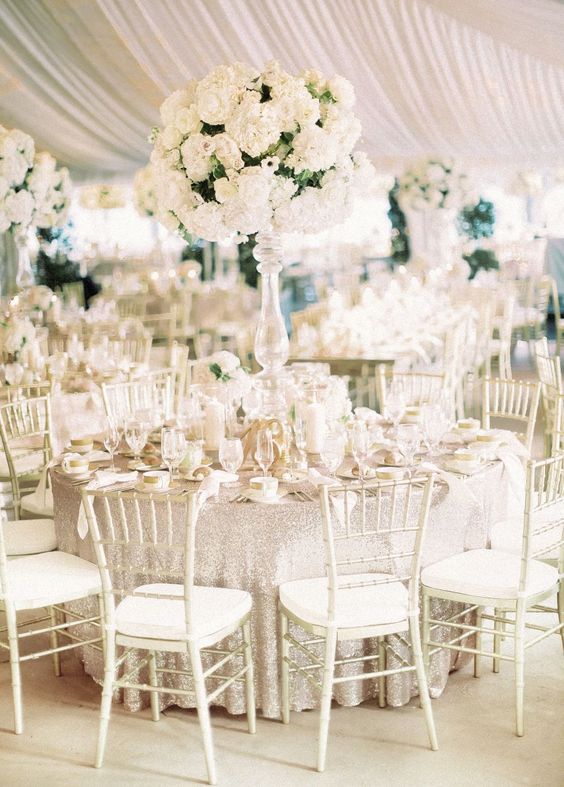an exquisite tall wedding centerpiece of white blooms and greenery is a gorgeous idea for a refined all white wedding