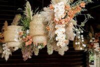 39 woven pandant lamps decorated with greenery, orange adn blush blooms and grasses are a cool alternative to a usual wedding centerpiece